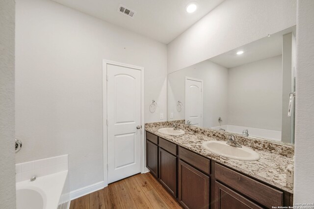6507 Thorpe, Converse, TX 78109 - bathroom with a bath, wood finished floors, a sink, and visible vents