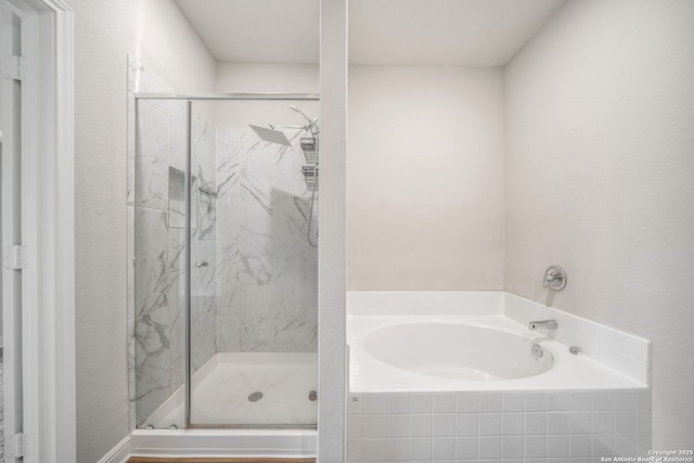 full bath featuring a garden tub and a marble finish shower