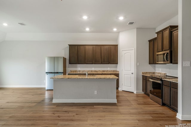 kitchen with dark brown cabinetry, appliances with stainless steel finishes, a sink, and recessed lighting