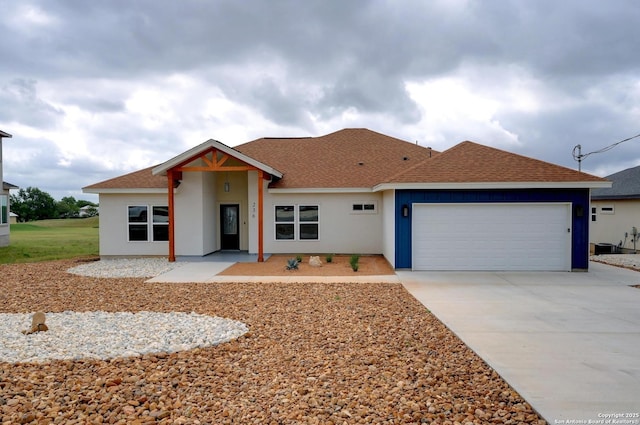 ranch-style house with a garage, stucco siding, roof with shingles, and concrete driveway