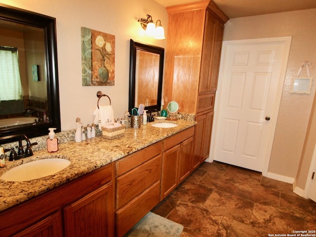 12365 Rudolph Rd, Atascosa, TX 78002 - full bath featuring baseboards, stone finish floor, a sink, and double vanity