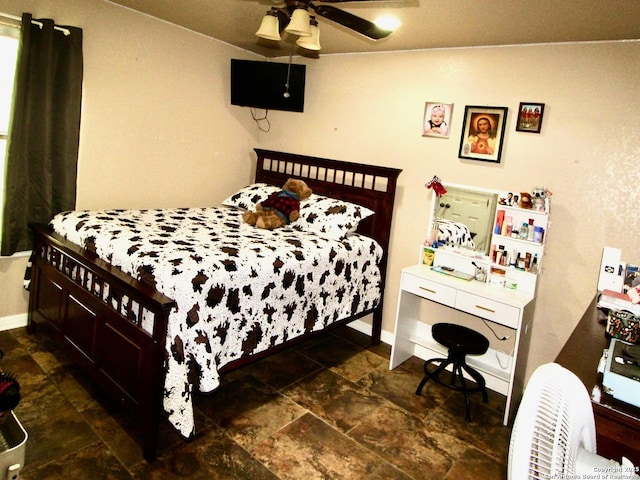 12365 Rudolph Rd, Atascosa, TX 78002 - bedroom featuring baseboards, stone finish flooring, and ceiling fan
