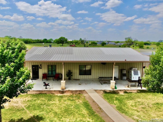 12365 Rudolph Rd, Atascosa, TX 78002 - back of house with board and batten siding, a lawn, and a patio