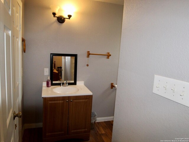 12365 Rudolph Rd, Atascosa, TX 78002 - bathroom with baseboards, wood finished floors, and vanity