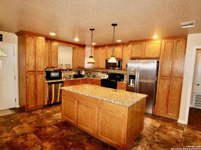 12365 Rudolph Rd, Atascosa, TX 78002 - kitchen with visible vents, light stone countertops, a center island, black appliances, and a textured ceiling