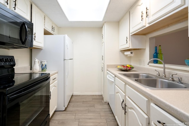 kitchen featuring white cabinets, a sink, and black appliances