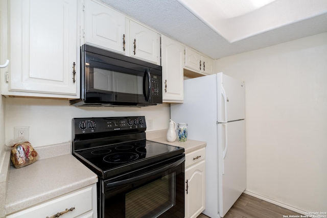 kitchen with black appliances, white cabinetry, wood finished floors, and light countertops