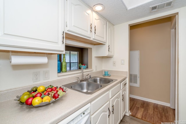 kitchen featuring light wood-type flooring, visible vents, white cabinetry, and a sink