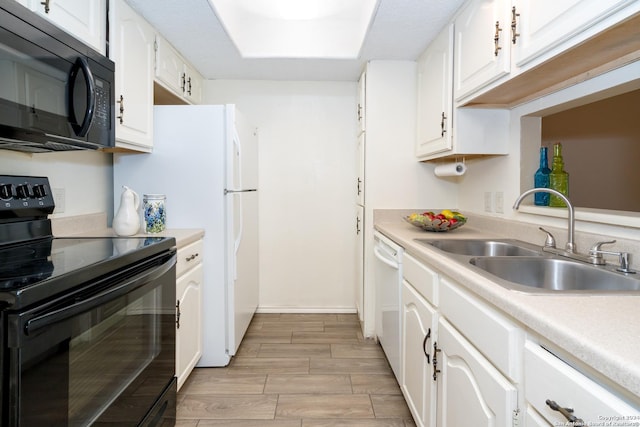 kitchen featuring white cabinets, wood tiled floor, light countertops, a sink, and black appliances