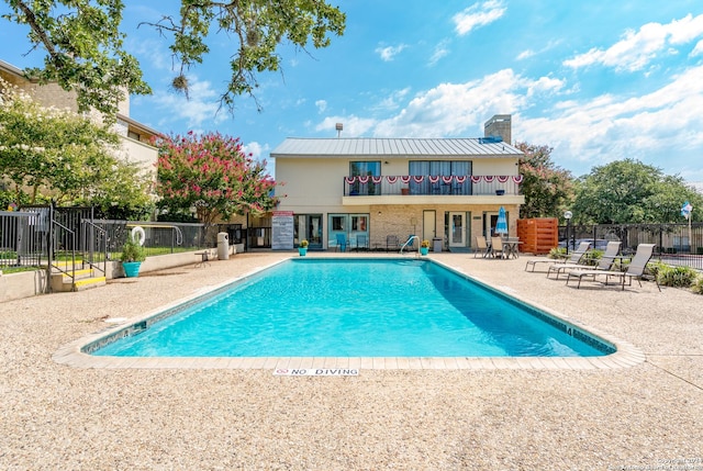 pool with a patio and fence