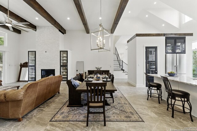 dining room with stairs, a towering ceiling, marble finish floor, and ceiling fan with notable chandelier