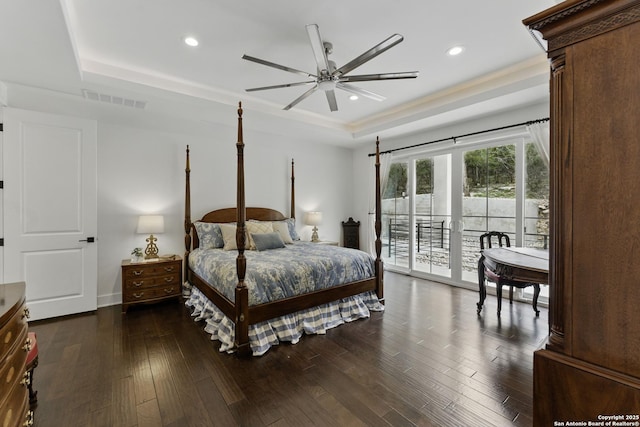 bedroom featuring recessed lighting, dark wood-style floors, a raised ceiling, visible vents, and access to exterior