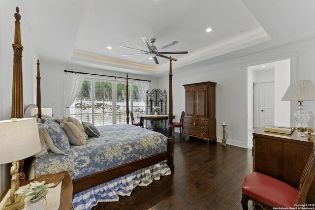 bedroom featuring baseboards, a tray ceiling, recessed lighting, and dark wood-style flooring