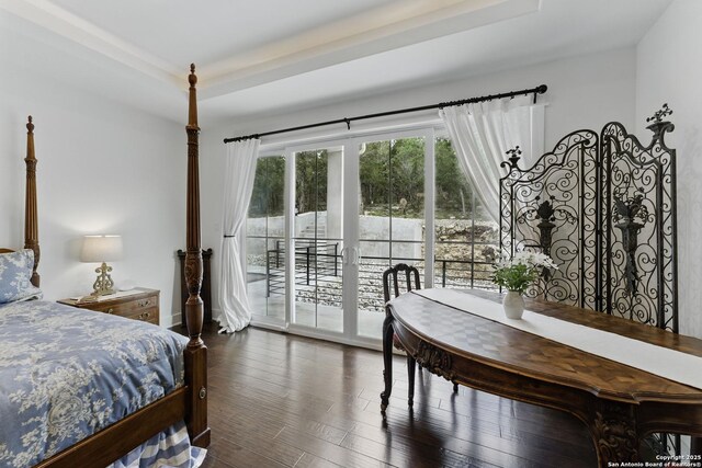 bedroom with dark wood finished floors and access to outside