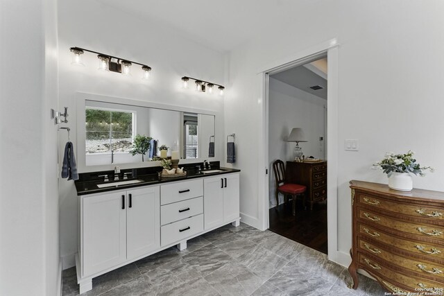 full bathroom with a sink and double vanity