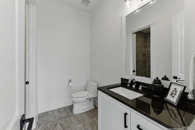 bathroom featuring baseboards, visible vents, vanity, and toilet