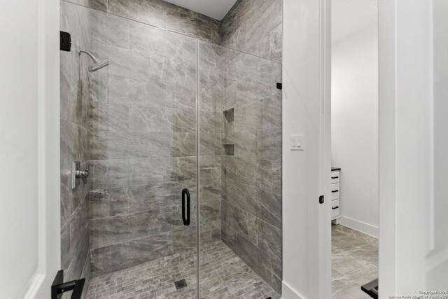 full bath featuring marble finish floor and a stall shower