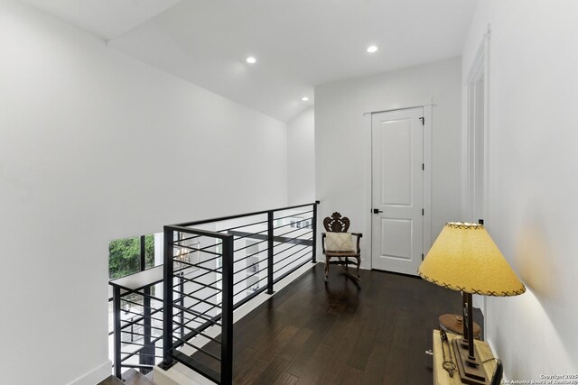 corridor with recessed lighting, wood finished floors, and an upstairs landing
