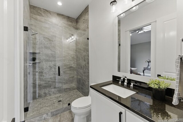 bathroom featuring a shower stall, toilet, vanity, connected bathroom, and ceiling fan