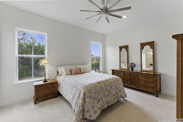 bedroom with light carpet, a ceiling fan, and baseboards