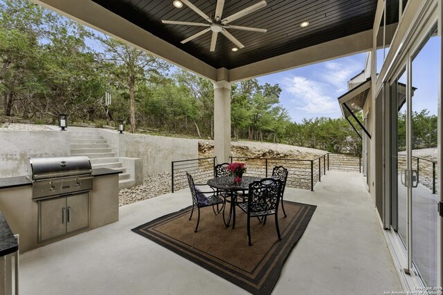 view of patio with stairway, outdoor dining area, an outdoor kitchen, area for grilling, and ceiling fan