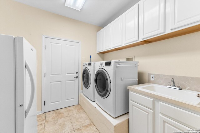 108 County Road 4325, Hondo, TX 78861 - laundry room featuring washing machine and clothes dryer, cabinet space, a sink, and light tile patterned floors