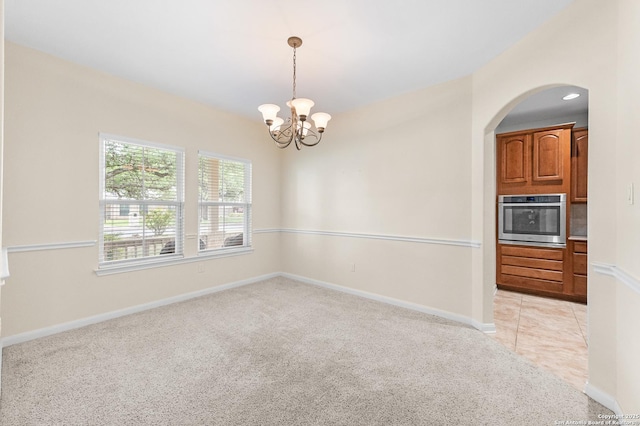 108 County Road 4325, Hondo, TX 78861 - unfurnished room with light colored carpet, arched walkways, an inviting chandelier, and baseboards
