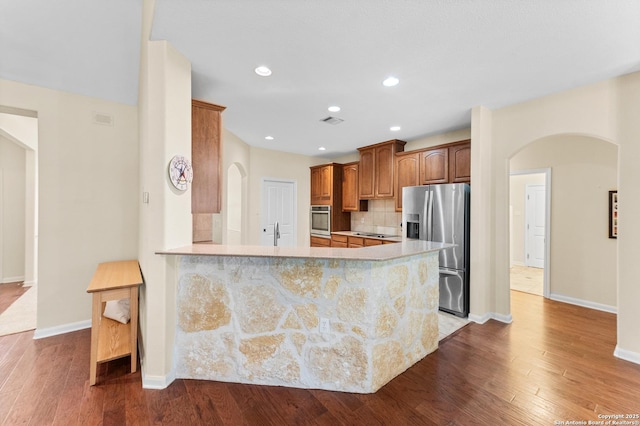 108 County Road 4325, Hondo, TX 78861 - kitchen with arched walkways, baseboards, wood finished floors, light countertops, and appliances with stainless steel finishes
