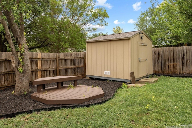 view of yard with a fenced backyard, an outdoor structure, and a storage shed