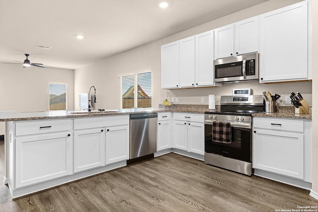 kitchen with a ceiling fan, a sink, a peninsula, appliances with stainless steel finishes, and visible vents