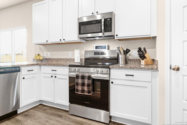 kitchen with white cabinets, wood finished floors, and appliances with stainless steel finishes