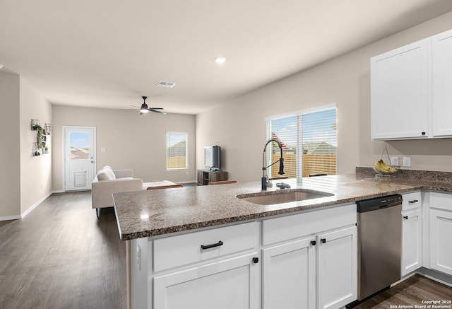 kitchen featuring a peninsula, dishwasher, a sink, and a wealth of natural light