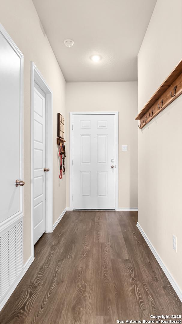 entryway with baseboards, dark wood-type flooring, and visible vents