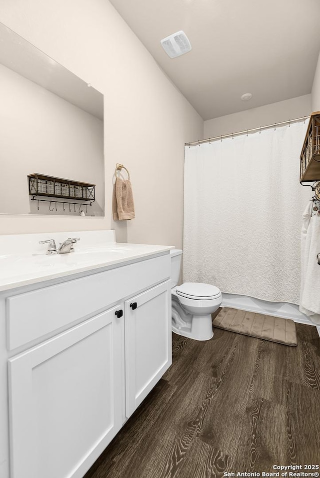 bathroom with wood finished floors, visible vents, toilet, vanity, and a shower with curtain