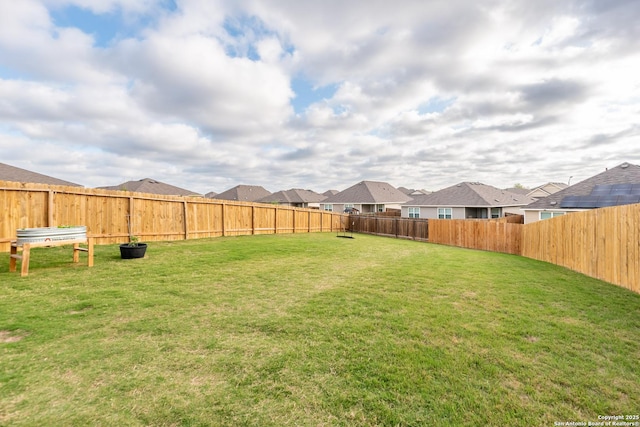 view of yard with a fenced backyard and a residential view