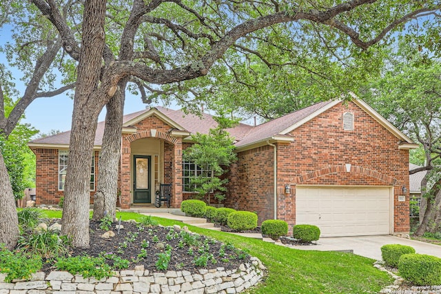 view of front facade with a shingled roof, driveway, and brick siding