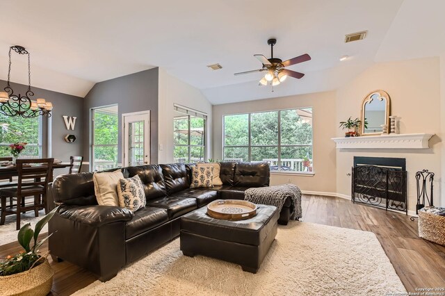 living room featuring lofted ceiling, visible vents, and a healthy amount of sunlight