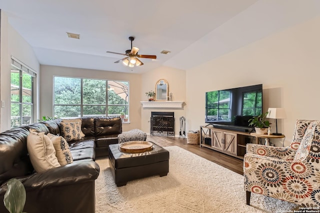 living area with lofted ceiling, wood finished floors, visible vents, and a ceiling fan