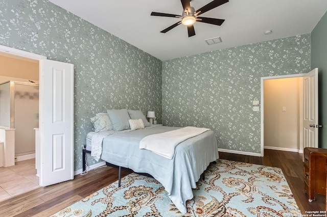 bedroom with a ceiling fan, visible vents, wood finished floors, and wallpapered walls