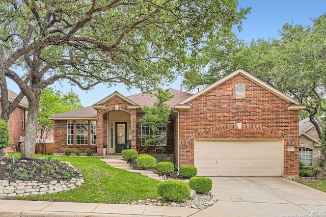 ranch-style home featuring a shingled roof, an attached garage, driveway, brick siding, and a front yard