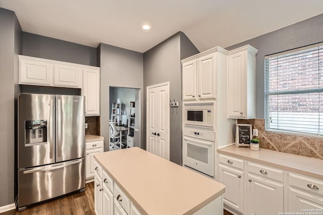 kitchen featuring backsplash, white cabinetry, dark wood-style floors, and white appliances