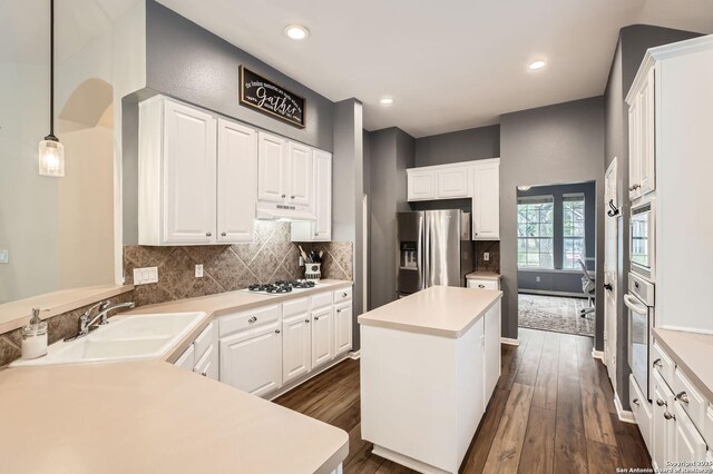 kitchen featuring dark wood-style floors, a sink, stainless steel refrigerator with ice dispenser, under cabinet range hood, and a kitchen island