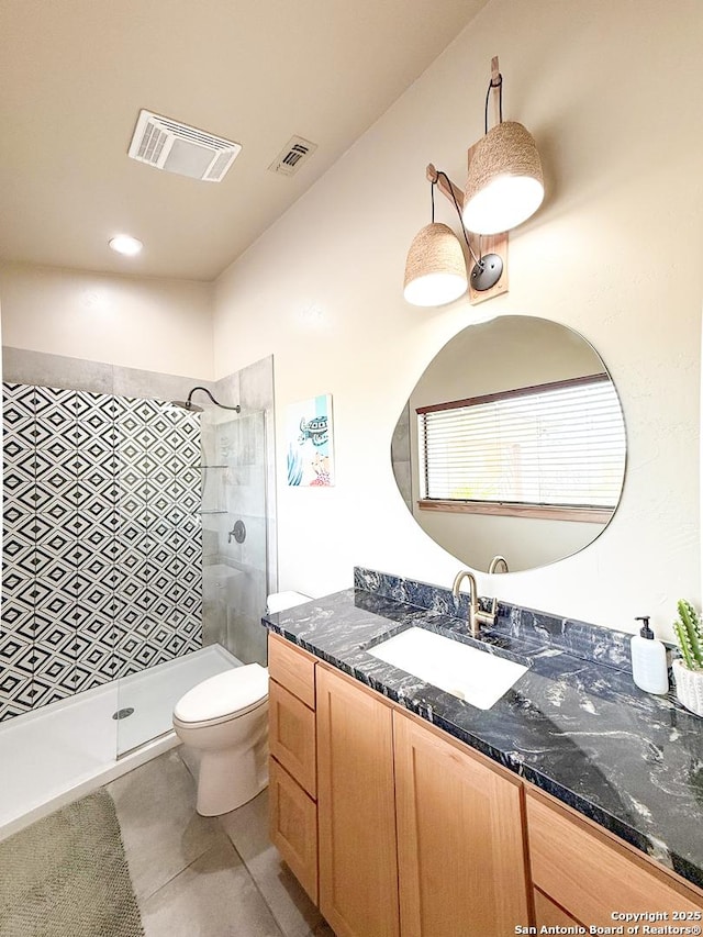bathroom featuring visible vents, toilet, a stall shower, and vanity