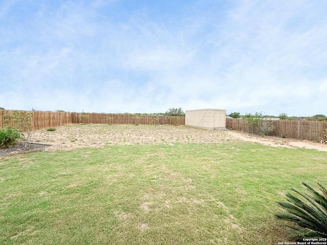 view of yard featuring a storage shed, a fenced backyard, and an outdoor structure