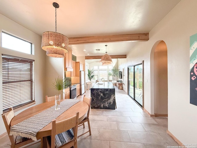 dining room featuring beam ceiling, baseboards, arched walkways, and a notable chandelier