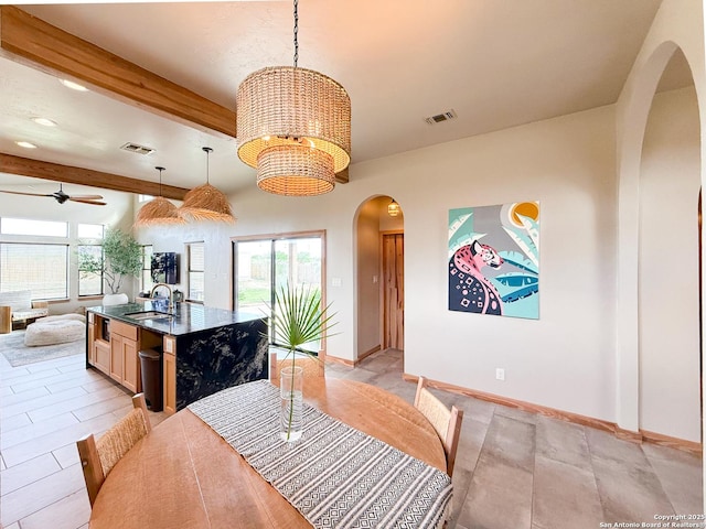 dining area featuring ceiling fan with notable chandelier, beam ceiling, visible vents, and arched walkways