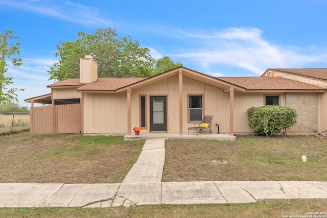 1051 Country Clb Unit 20, Seguin, TX 78155 - view of front of home featuring a chimney, roof with shingles, fence, and a front yard