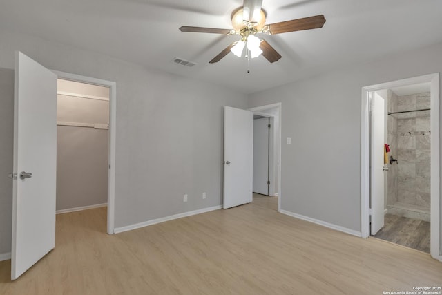 1051 Country Clb Unit 20, Seguin, TX 78155 - unfurnished bedroom with wood finished floors, a closet, a spacious closet, baseboards, and visible vents