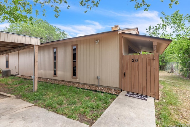 1051 Country Clb Unit 20, Seguin, TX 78155 - view of home's exterior with fence, a chimney, a yard, and cooling unit