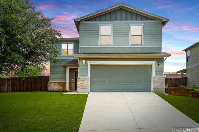 view of front of house with concrete driveway, fence, brick siding, an attached garage, and a lawn